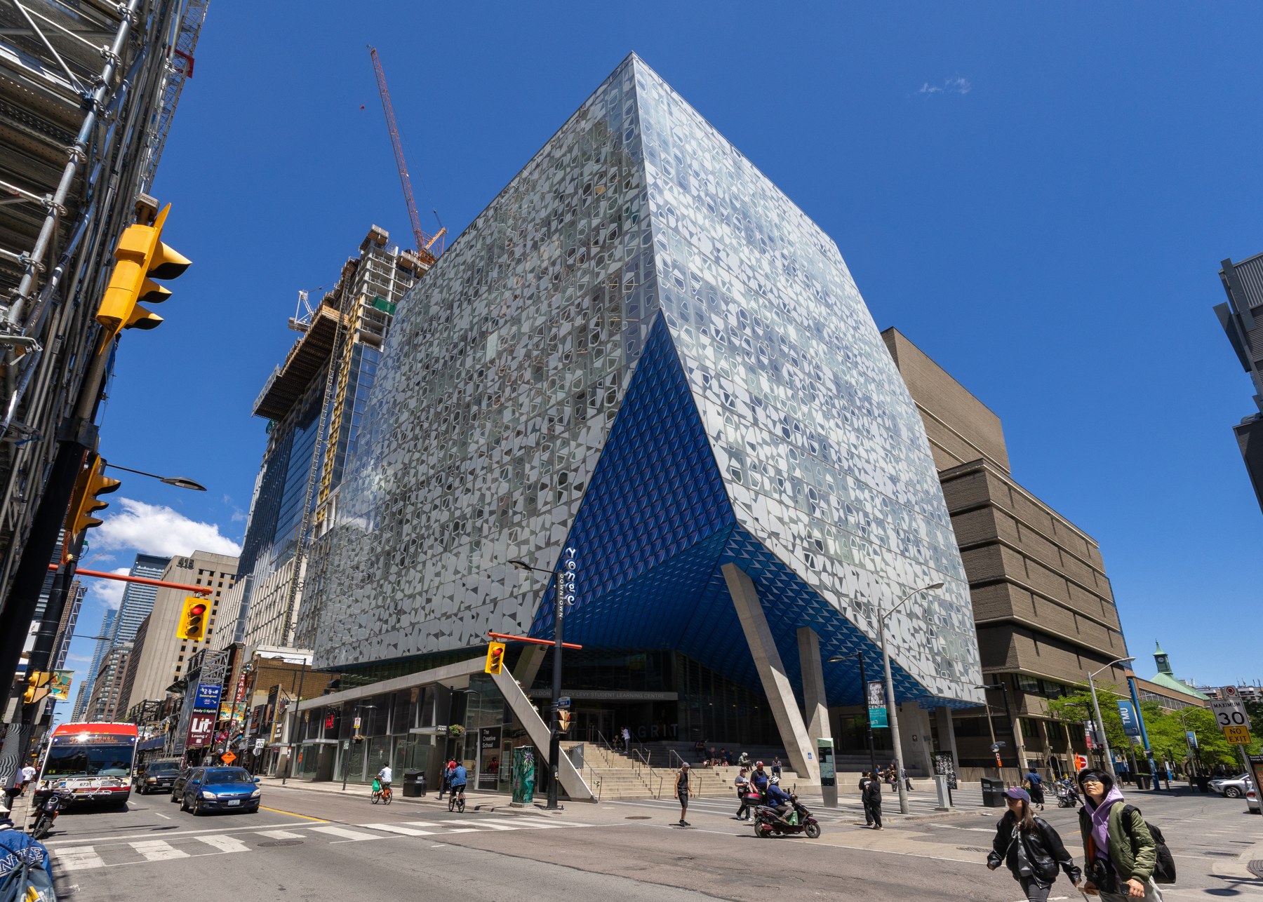 Toronto Metropolitan University's glass Student Learning Centre beneath a clear blue sky