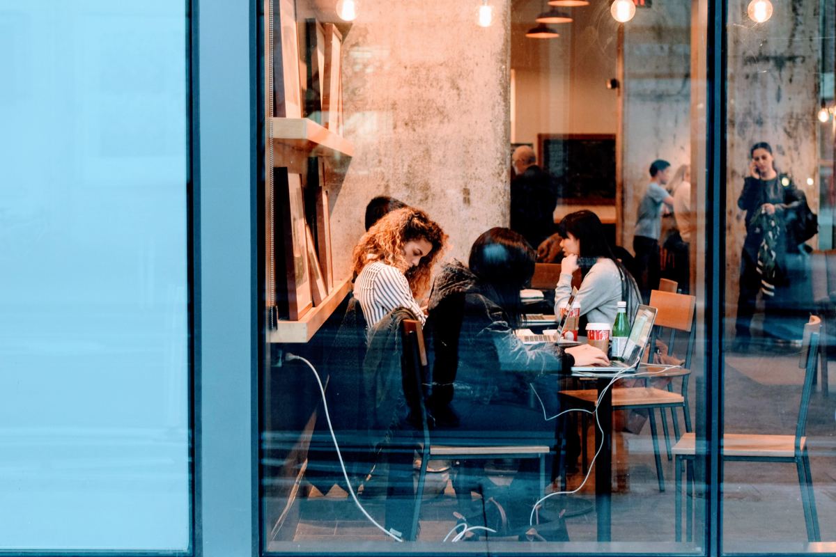 People working and collaborating in a café setting, representing Toronto startup culture that thrives in informal coffee shops and shared workspace environments.