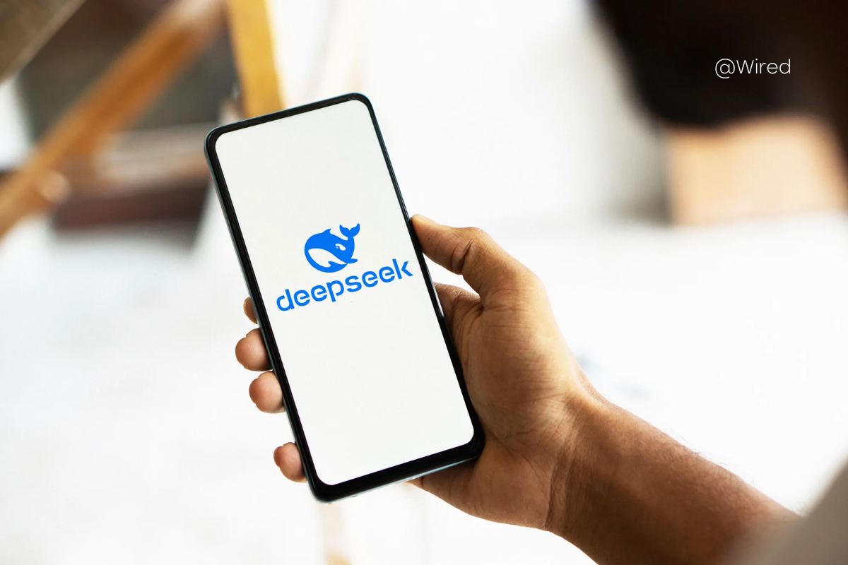 The picture shows a person's hand holding a phone with DeepSeek in the background.