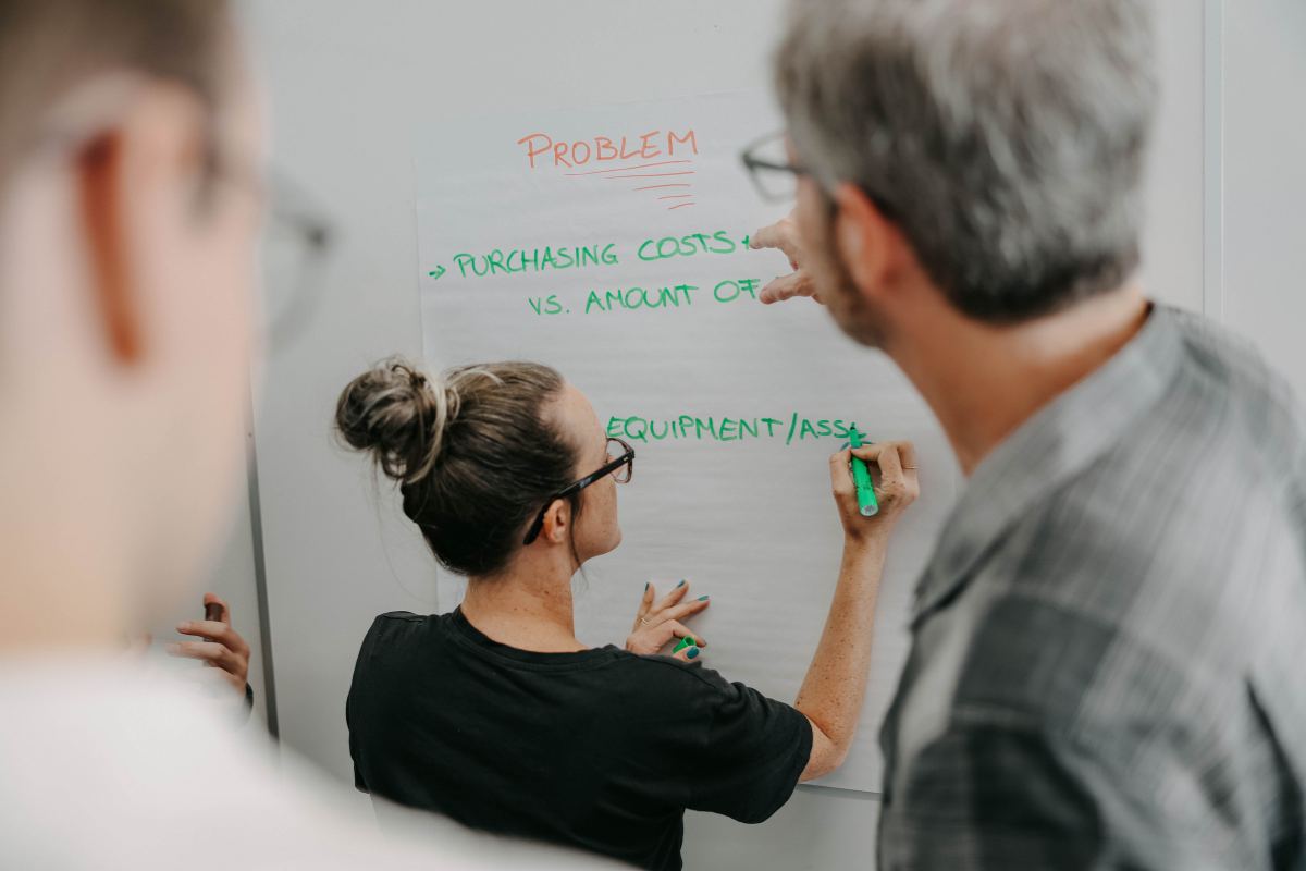 Woman writing on a whiteboard.