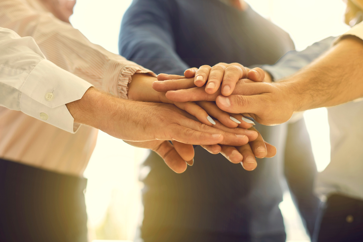 The picture shows the hands of people representing collaboration in a team.