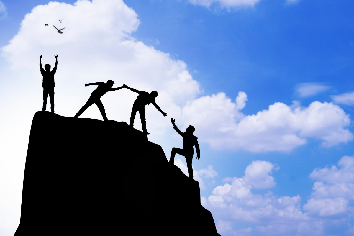 People helping each other climb the mountain which represents leadership.