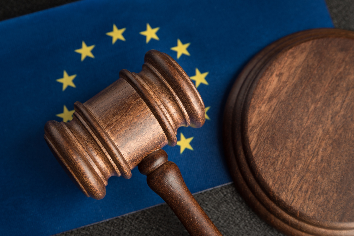 The picture shows the EU flag and the judge's gavel, which symbolizes the regulatory landscape in Europe.