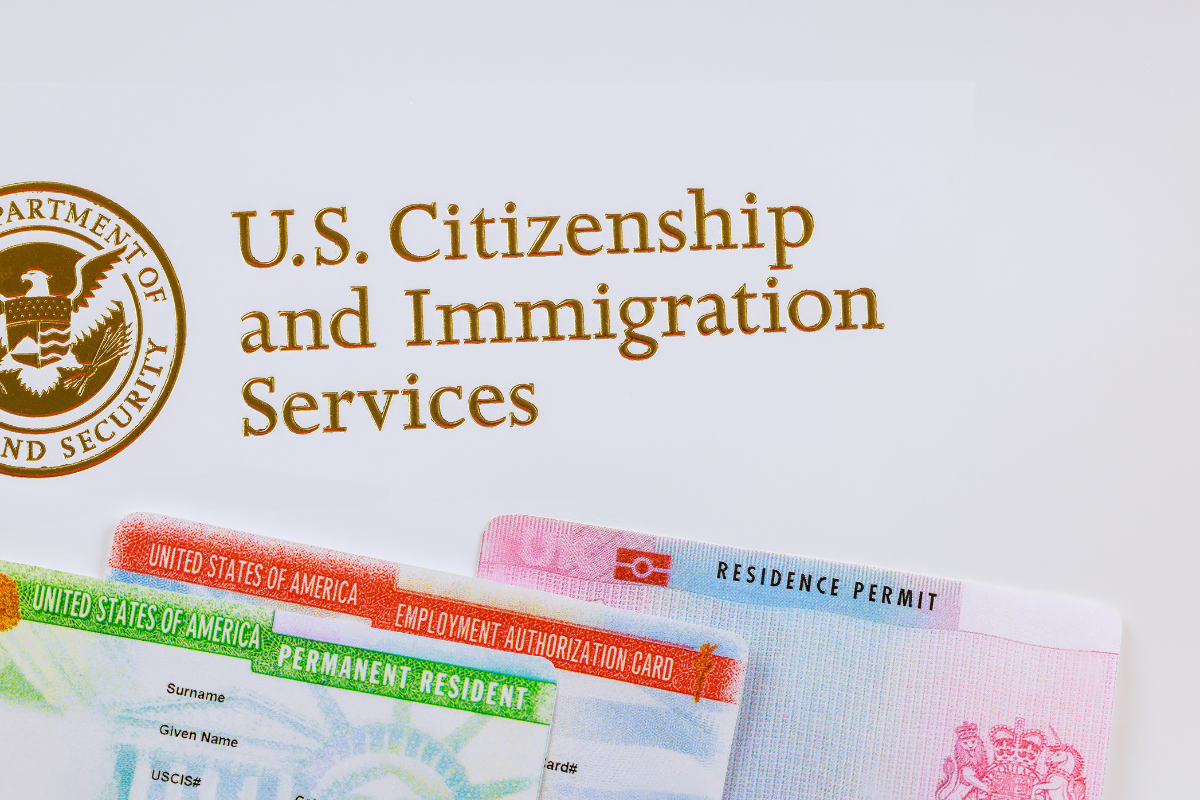 U.S. Citizenship and Immigration Services with a couple of documents beside it.