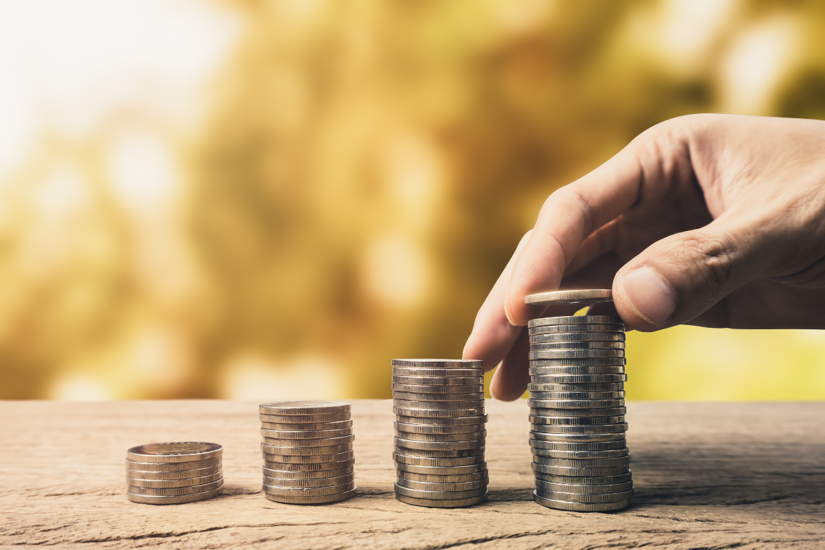 The image shows 4 stacks of coins and a hand, representing Quick access to funding from angel investors.