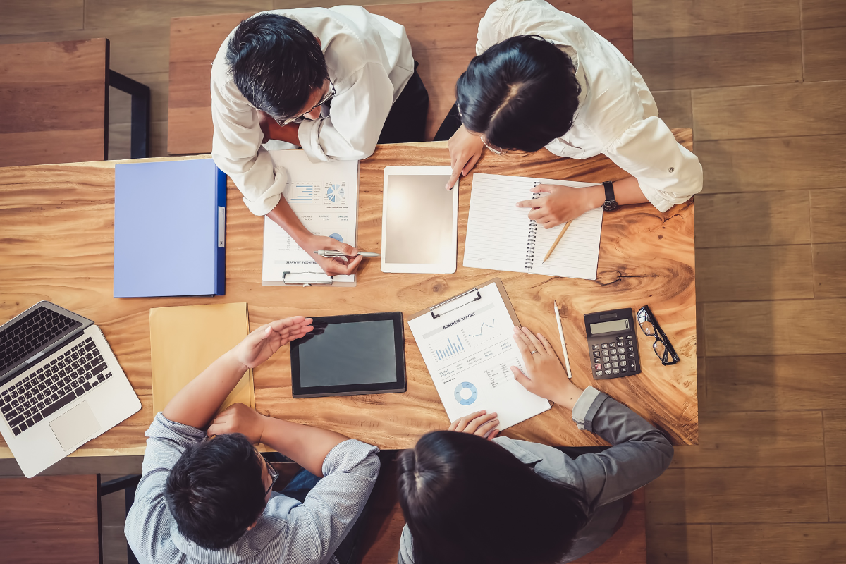 The image also shows a group of people working on tablets and computers, symbolizing the importance of leveraging technology and innovation to develop a strong startup idea.