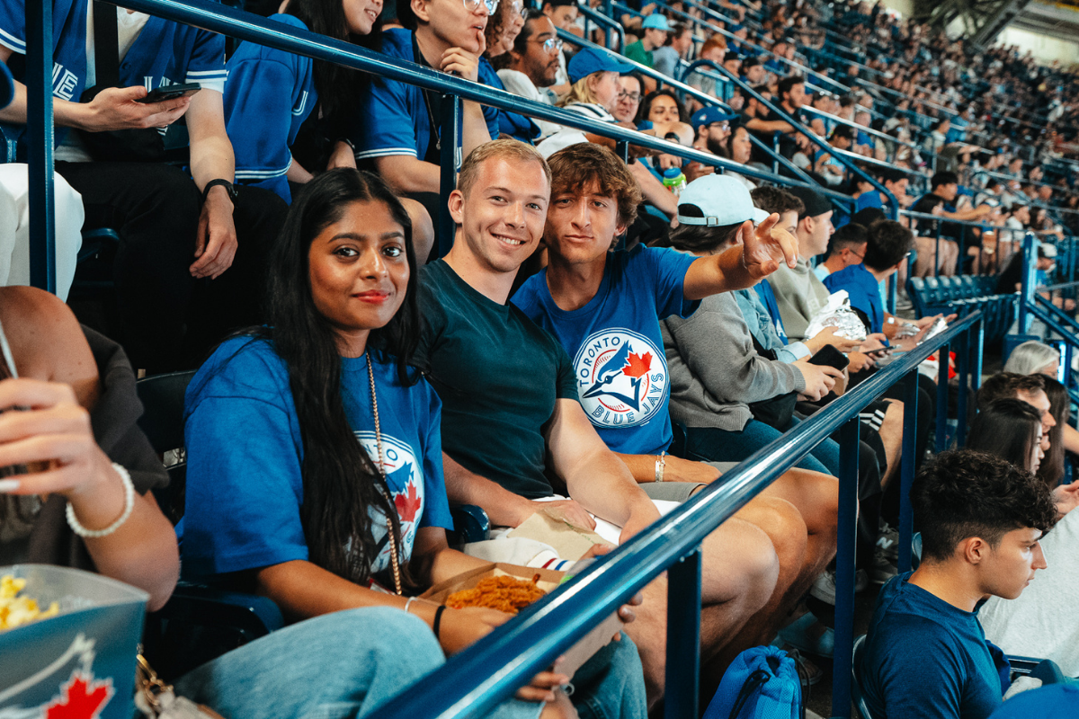 One woman and two men attending a Blue Jays game.