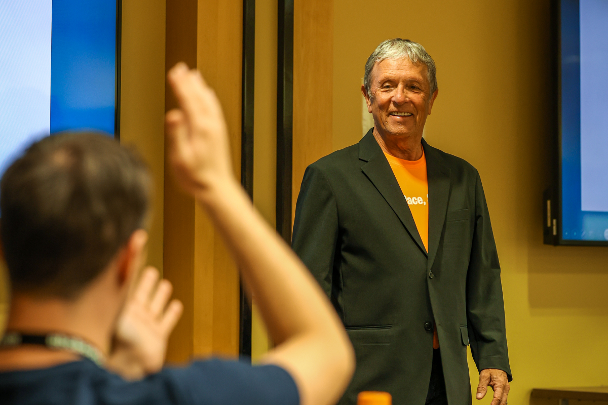 The image shows Buddy Burke—an entrepreneur and certified World Class Speaking Coach—giving a lecture at ABC Silicon Valley about public speaking.