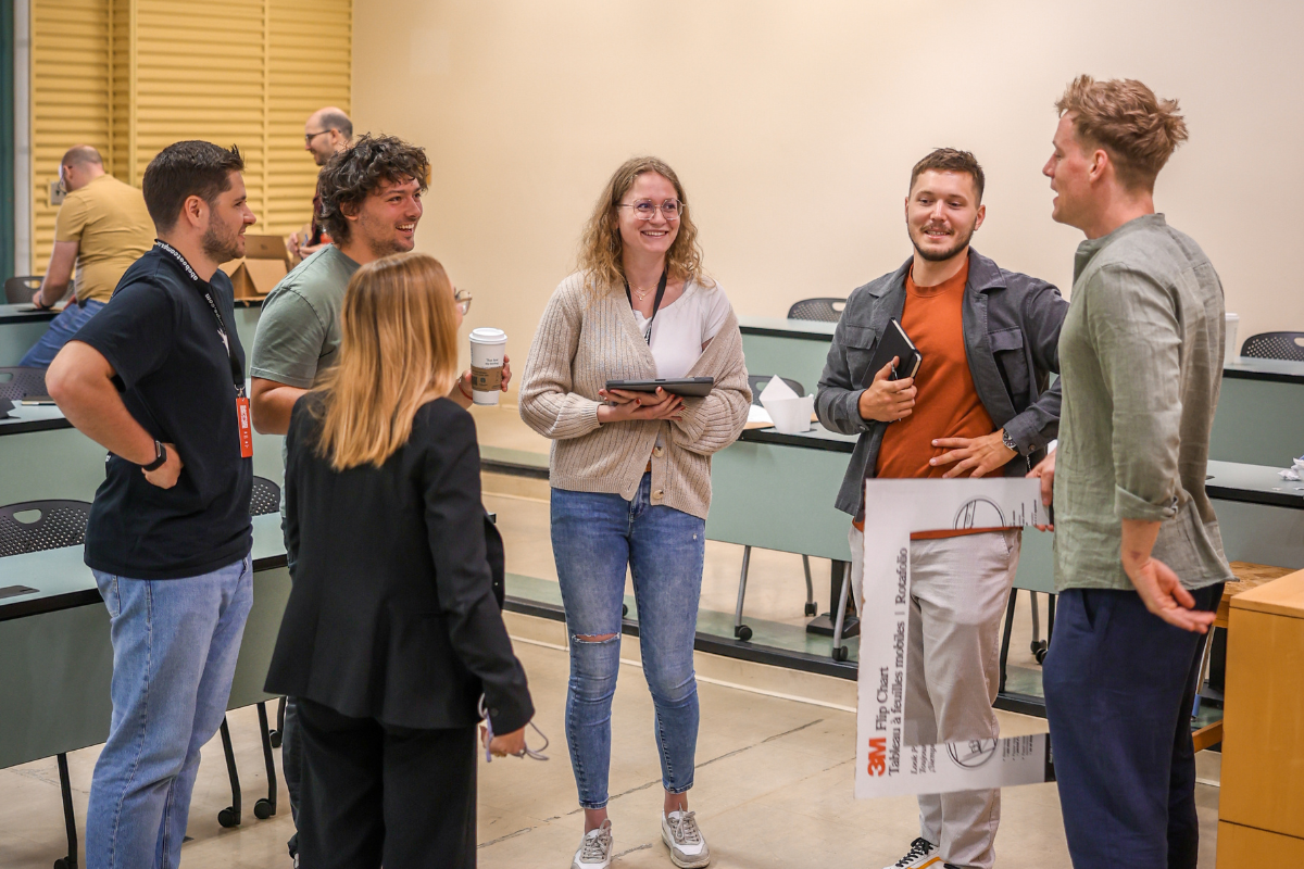 A group of people standing in a circle, discussing a solution to a problem.